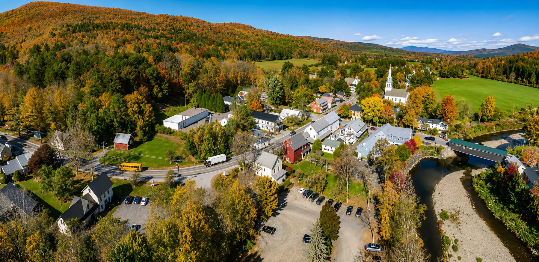 view of a Poconos town surrounded by autumn mountains and countryside
