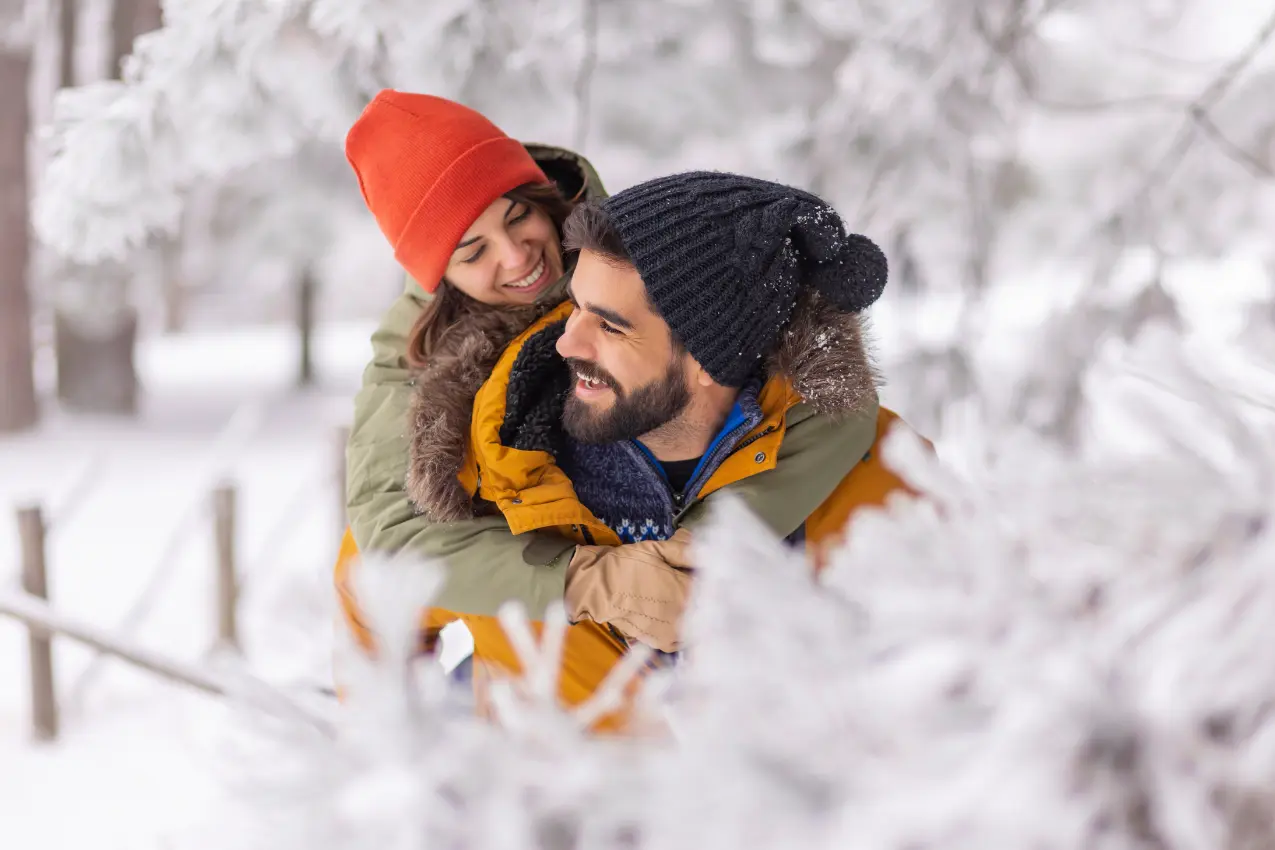 couple on winter vacation in poconos, boyfriend piggybacking