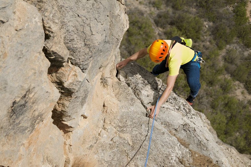 A man rock climbing on a big boulder in the Poconos