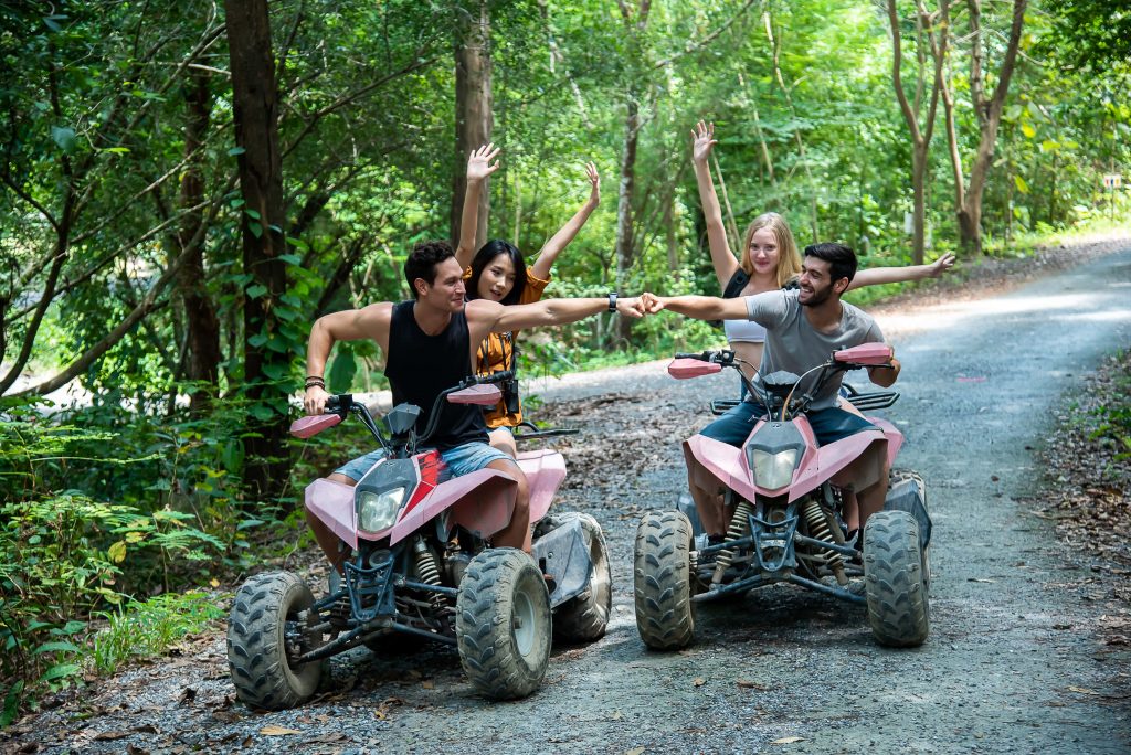 Guys enjoying an ATV riding through the lush forest trail in the Poconos